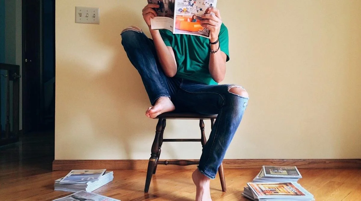 a woman sitting in a chair reading a book