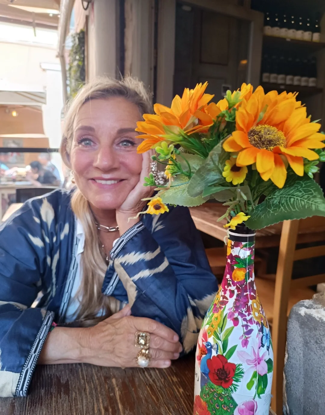 una persona seduta a un tavolo con fiori