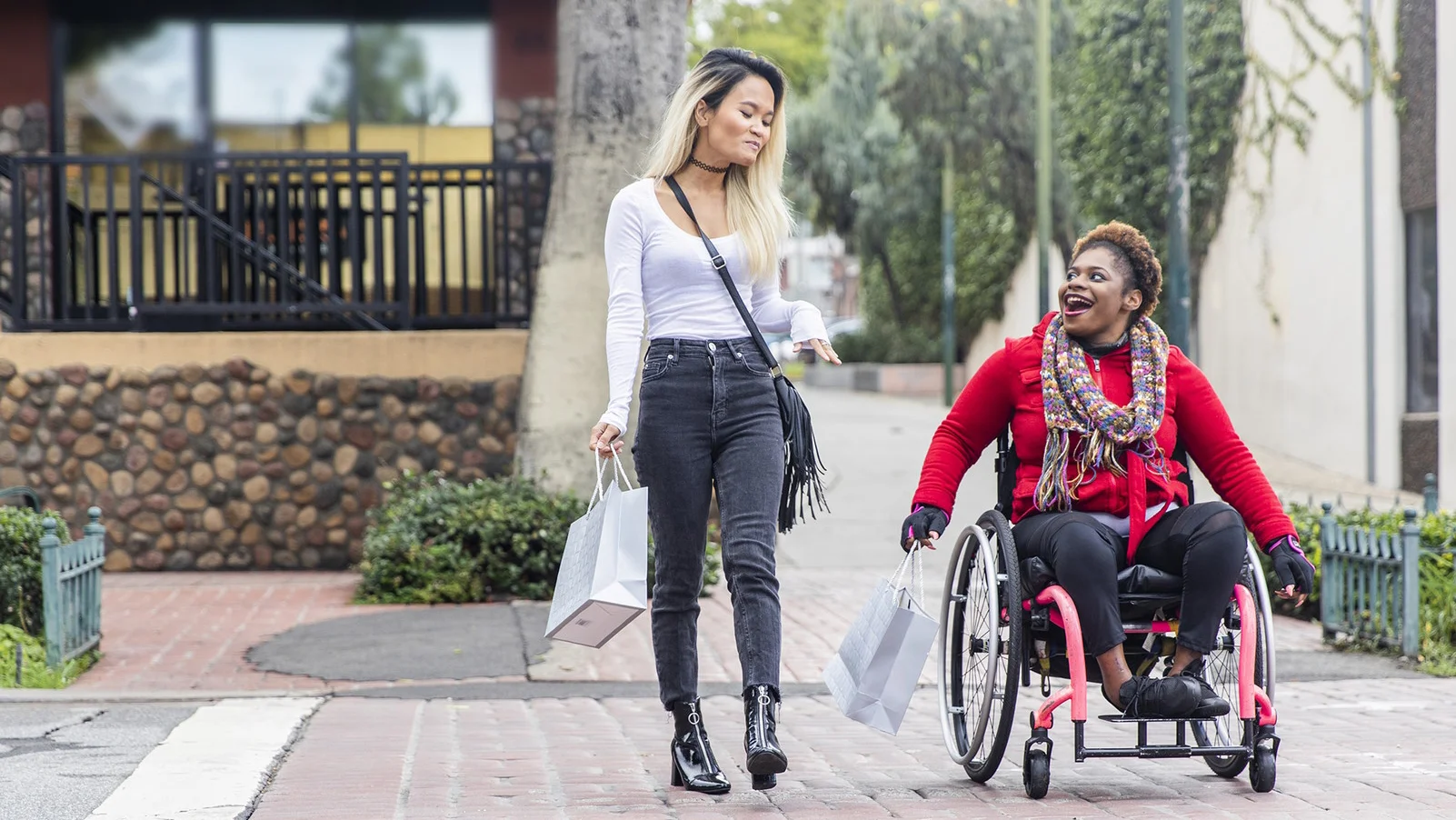 a woman pushing a man in a wheelchair