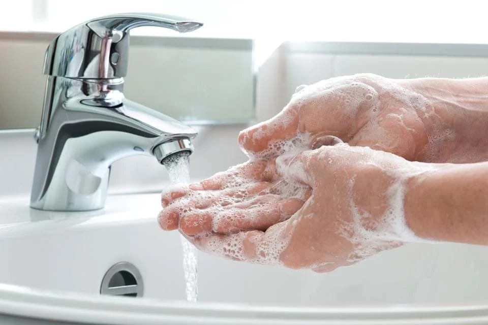a person washing their hands in a sink