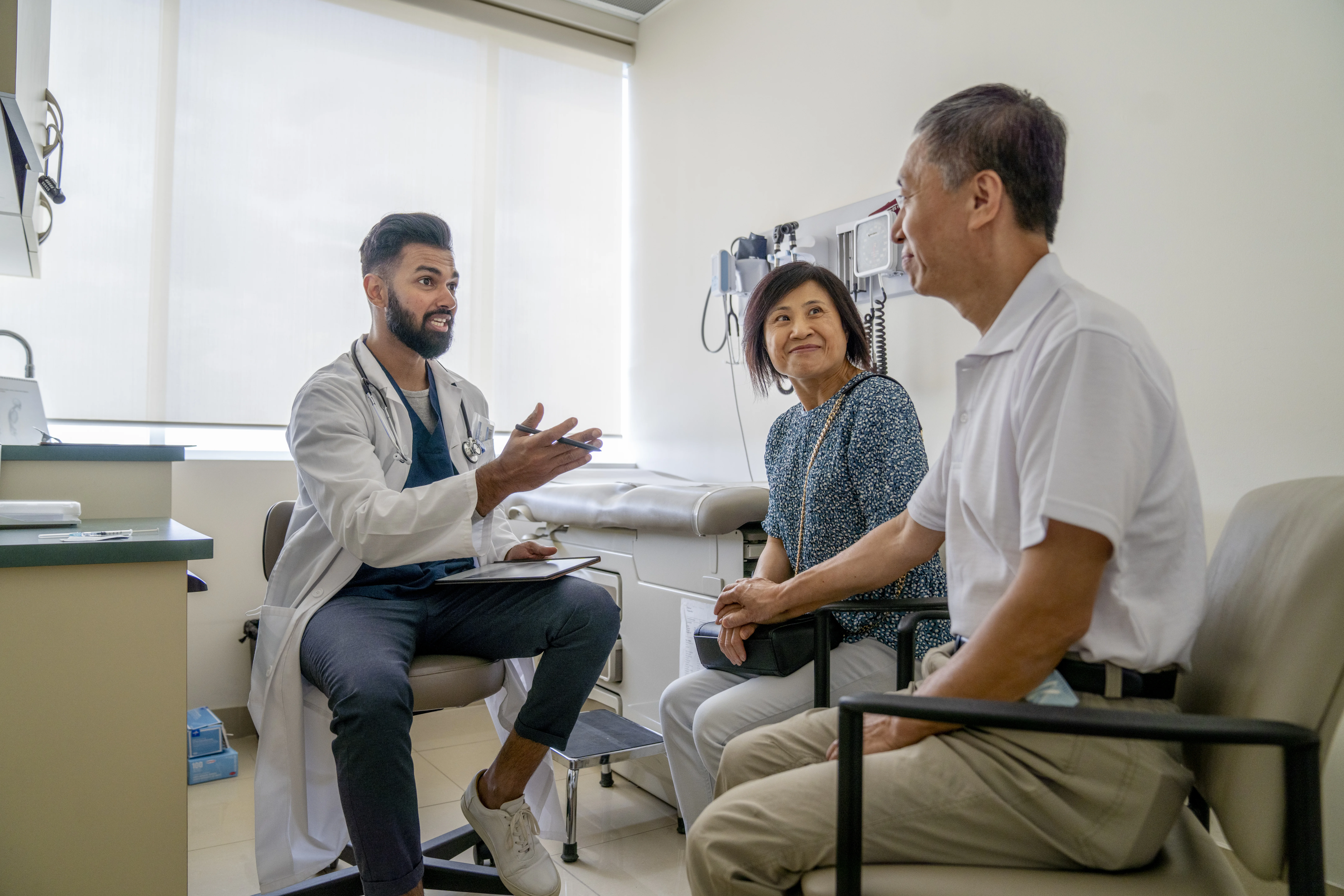 A doctor guiding an elderly couple in the hospital through the Umbrella breathing exercises.